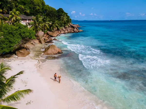 Anse Patates, La Digue Seychelles, young couple men and woman on a tropical beach during a luxury vacation in the Seychelles. Tropical beach Anse Patates, La Digue Seychelles — Stockfoto