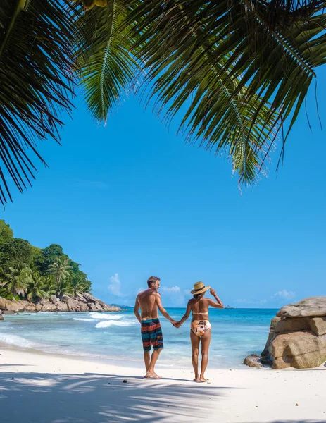 Anse Patates, La Digue Seychellen, jong stel mannen en vrouw op een tropisch strand tijdens een luxe vakantie op de Seychellen. Tropisch strand Anse Patates, La Digue Seychellen — Stockfoto