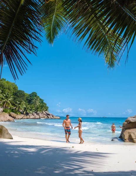 Anse Patates, La Digue Seyşeller, Seyşeller 'de lüks bir tatil sırasında tropik bir plajda yaşayan genç bir çift. Tropik sahil Anse Patates, La Digue Seyşeller