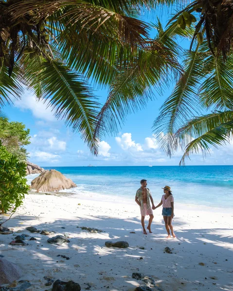 Anse Patates, La Digue Seychellen, jong stel mannen en vrouw op een tropisch strand tijdens een luxe vakantie op de Seychellen. Tropisch strand Anse Patates, La Digue Seychellen — Stockfoto