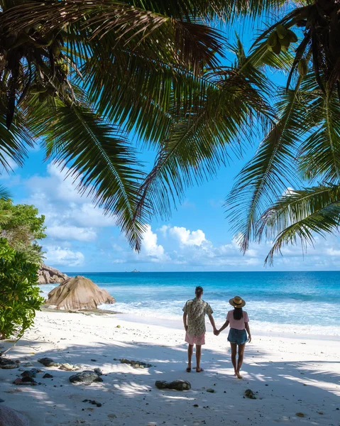 Anse Patates, La Digue Seychelles, young couple men and woman on a tropical beach during a luxury vacation in the Seychelles. Tropical beach Anse Patates, La Digue Seychelles — Stockfoto