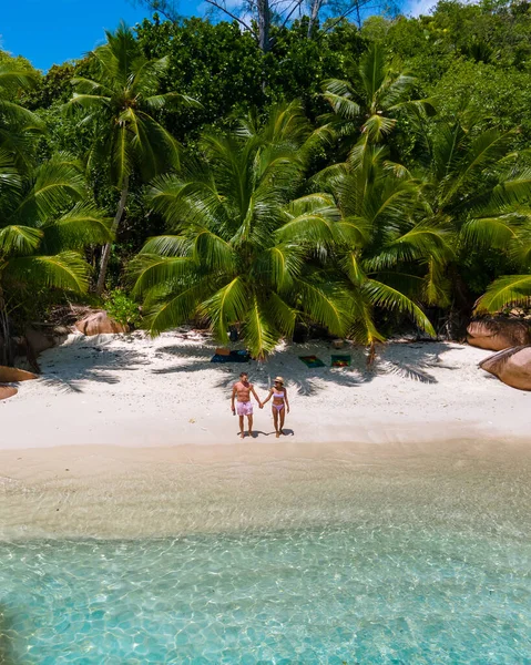 Anse Lazio Praslin Seychelles, young couple men and woman on a tropical beach during a luxury vacation in the Seychelles. Tropical beach Anse Lazio Praslin Seychelles — ストック写真