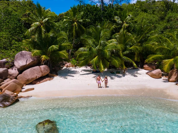 Anse Lazio Praslin Seychelles, young couple men and woman on a tropical beach during a luxury vacation in the Seychelles. Tropical beach Anse Lazio Praslin Seychelles — стоковое фото