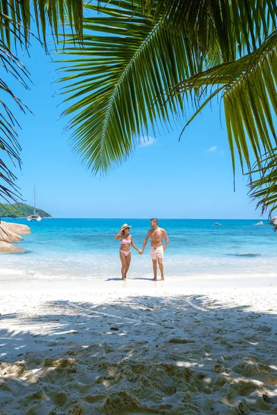 Anse Lazio Praslin Seychelles, jovem casal de homens e mulheres em uma praia tropical durante umas férias de luxo nas Seychelles. Praia tropical Anse Lazio Praslin Seychelles — Fotografia de Stock