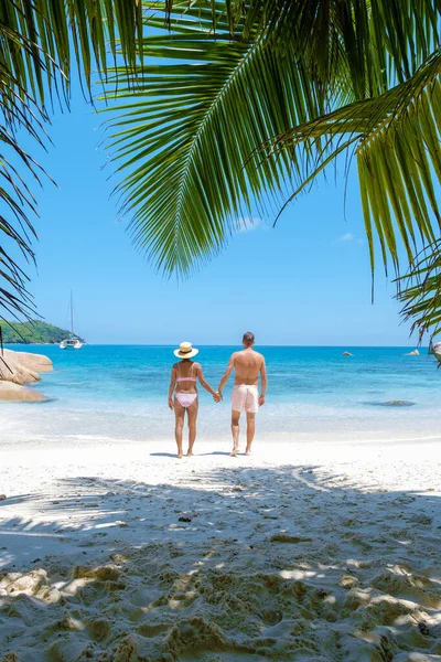 Anse Lazio Praslin Seychellen, jong stel mannen en vrouw op een tropisch strand tijdens een luxe vakantie op de Seychellen. Tropisch strand Anse Lazio Praslin Seychellen — Stockfoto