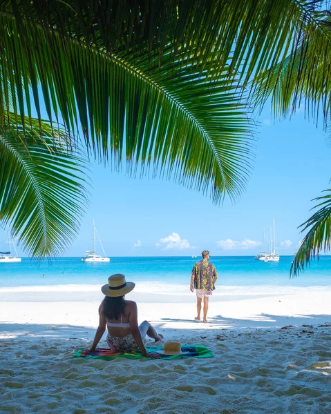 Anse Lazio Praslin Seychelles, pareja joven de hombres y mujeres en una playa tropical durante unas vacaciones de lujo en las Seychelles. Playa tropical Anse Lazio Praslin Seychelles —  Fotos de Stock