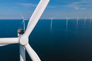Huge windmill turbines, Offshore Windmill farm in the ocean Westermeerwind park , windmills isolated at sea on a beautiful bright day Netherlands Flevoland Noordoostpolder