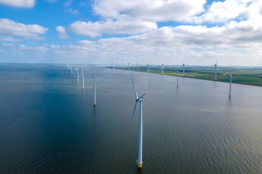 Huge windmill turbines, Offshore Windmill farm in the ocean Westermeerwind park , windmills isolated at sea on a beautiful bright day Netherlands Flevoland Noordoostpolder