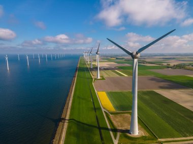 Huge windmill turbines, Offshore Windmill farm in the ocean Westermeerwind park , windmills isolated at sea on a beautiful bright day Netherlands Flevoland Noordoostpolder