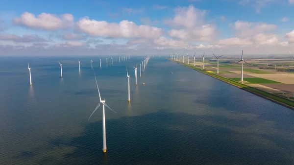 Huge windmill turbines, Offshore Windmill farm in the ocean Westermeerwind park , windmills isolated at sea on a beautiful bright day Netherlands Flevoland Noordoostpolder — стоковое фото