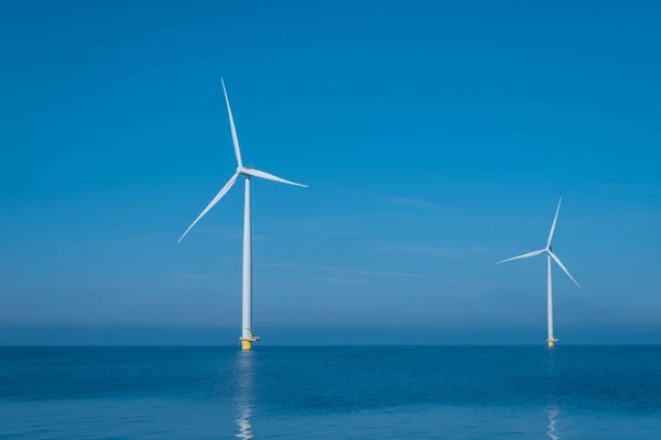 Huge windmill turbines, Offshore Windmill farm in the ocean Westermeerwind park , windmills isolated at sea on a beautiful bright day Netherlands Flevoland Noordoostpolder — стокове фото