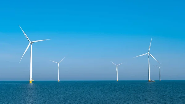 巨大的风车涡轮机，大海中的离岸风车农场，西风公园里的风车，在一个美丽的阳光明媚的日子隔离在海上的荷兰弗洛尔和诺德鲁斯特沃尔德 — 图库照片