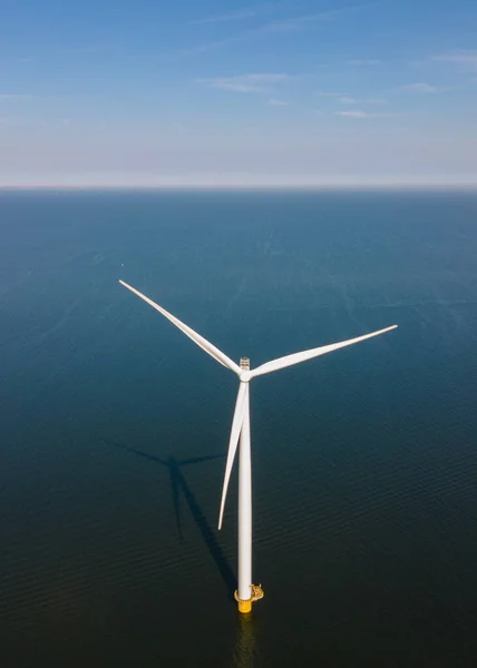 Huge windmill turbines, Offshore Windmill farm in the ocean Westermeerwind park , windmills isolated at sea on a beautiful bright day Netherlands Flevoland Noordoostpolder Stock Picture