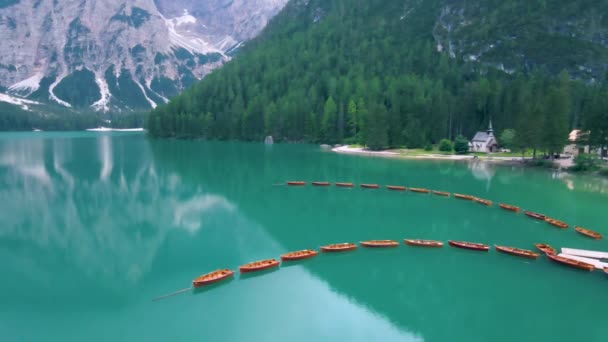 Prachtig landschap van Braies Lake Lago di Braies romantische plek met houten brug en boten op het alpenmeer, Alpen bergen, Dolomieten, Italië, Europa — Stockvideo