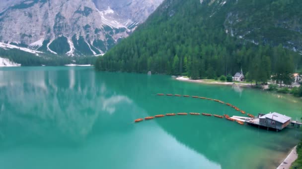 Schöne Landschaft des Pragser Sees romantischer Ort mit Holzbrücke und Booten auf dem Alpensee, Alpen, Dolomiten, Italien, Europa — Stockvideo