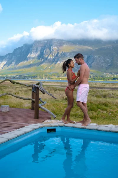 Coppia uomo e donna in piscina di lì lodge in vacanza in Sud Africa con vista sulle montagne vicino Hermanus — Foto Stock