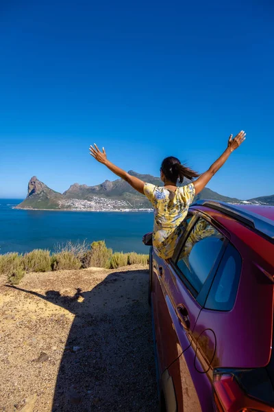 Mujer fuera de la ventana del coche viaje por carretera con las manos arriba, coche en Chapmans Peak Drive en Ciudad del Cabo Sudáfrica mirando hacia el océano —  Fotos de Stock