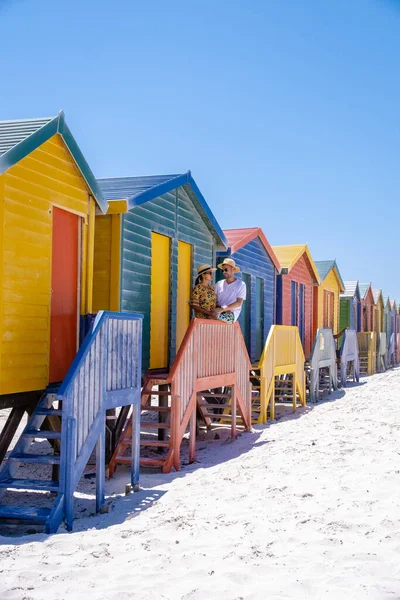 Couple man and woman visiting the beach at Muizenberg, colorful beach house at Muizenberg beach Cape Town,beach huts, Muizenberg, Cape Town, False Bay, South Africa — 图库照片