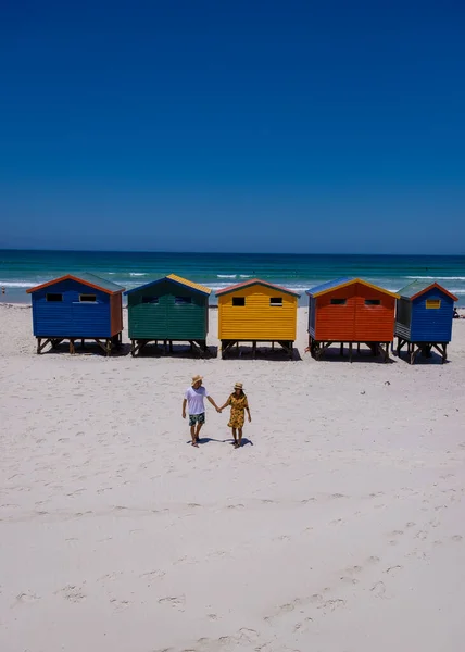 Couple man and woman visiting the beach at Muizenberg, colorful beach house at Muizenberg beach Cape Town,beach huts, Muizenberg, Cape Town, False Bay, South Africa — Φωτογραφία Αρχείου