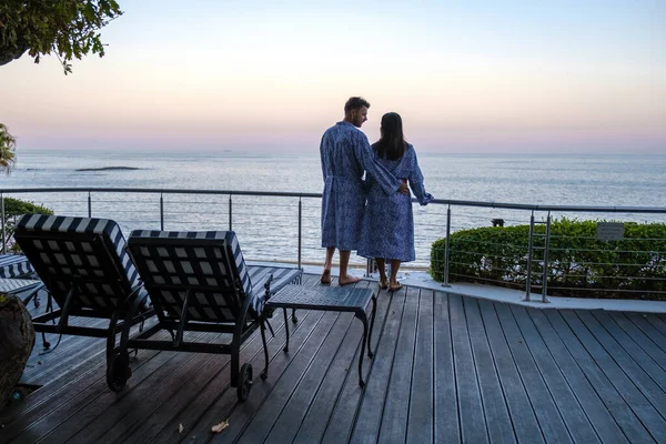 Paar man en vrouw in de voorkant van Infinity zwembad met uitzicht op de oceaan van Kaapstad Zuid-Afrika, man en vrouw in het zwembad tijdens zonsondergang — Stockfoto