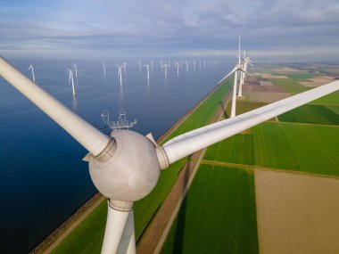 Huge windmill turbines, Offshore Windmill farm in the ocean Westermeerwind park , windmills isolated at sea on a beautiful bright day Netherlands Flevoland Noordoostpolder