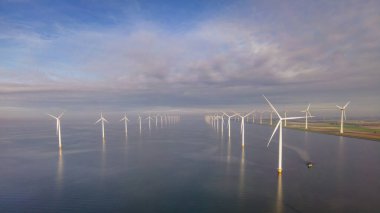 Huge windmill turbines, Offshore Windmill farm in the ocean Westermeerwind park , windmills isolated at sea on a beautiful bright day Netherlands Flevoland Noordoostpolder