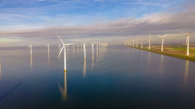 Huge windmill turbines, Offshore Windmill farm in the ocean Westermeerwind park , windmills isolated at sea on a beautiful bright day Netherlands Flevoland Noordoostpolder