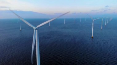Okyanustaki yel değirmeni parkı, yeşil enerji üreten yel değirmeni türbinlerinin insansız hava görüntüsü, Hollanda 'da denizde izole edilmiş yel değirmenleri.