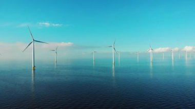 Okyanustaki yel değirmeni parkı, yeşil enerji üreten yel değirmeni türbinlerinin insansız hava görüntüsü, Hollanda 'da denizde izole edilmiş yel değirmenleri.