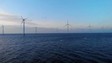 Okyanustaki yel değirmeni parkı, yeşil enerji üreten yel değirmeni türbinlerinin insansız hava görüntüsü, Hollanda 'da denizde izole edilmiş yel değirmenleri.