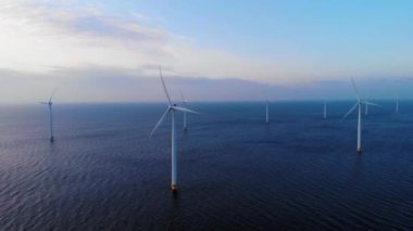 Okyanustaki yel değirmeni parkı, yeşil enerji üreten yel değirmeni türbinlerinin insansız hava görüntüsü, Hollanda 'da denizde izole edilmiş yel değirmenleri.