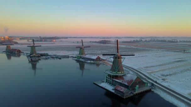 Дерев'яний вітряк у вітряк Заансе-Шанс взимку з сніговим ландшафтом, покритий снігом дерев'яні історичні вітряні млини Заансе Шанс Нідерланди Голландія — стокове відео
