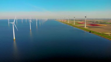 Okyanustaki yel değirmeni parkı, yeşil enerji üreten yel değirmeni türbinlerinin insansız hava görüntüsü, Hollanda 'da denizde izole edilmiş yel değirmenleri.