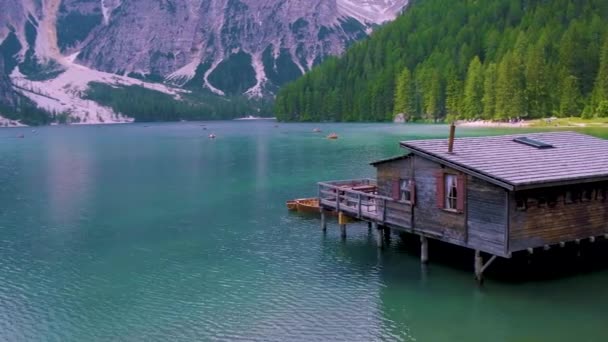 Bela paisagem de Braies Lago di Braies lugar romântico com ponte de madeira e barcos no lago alpino, Alpes Montanhas, Dolomitas, Itália, Europa — Vídeo de Stock