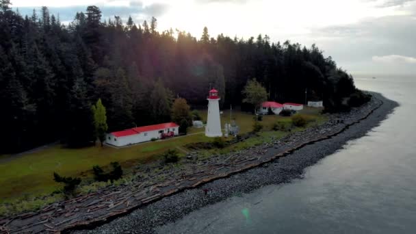 Vancouver Island, Canadá, Quadra Island antiguo faro histórico en Cape Mudge pareja en impermeable amarillo durante la tormenta por la costa — Vídeo de stock