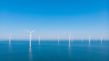 Okyanustaki yel değirmeni parkı, yeşil enerji üreten yel değirmeni türbinlerinin insansız hava görüntüsü Hollanda 'da denizde izole edilmiş yel değirmenleri. Yüksek kalite 4k görüntü