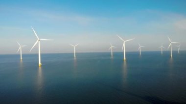 Okyanustaki yel değirmeni parkı, yeşil enerji üreten yel değirmeni türbinlerinin insansız hava görüntüsü Hollanda 'da denizde izole edilmiş yel değirmenleri. Yüksek kalite 4k görüntü
