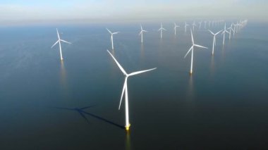Okyanustaki yel değirmeni parkı, yeşil enerji üreten yel değirmeni türbinlerinin insansız hava görüntüsü Hollanda 'da denizde izole edilmiş yel değirmenleri. Yüksek kalite 4k görüntü