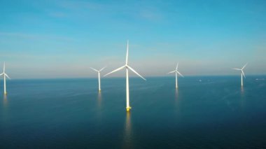 Okyanustaki yel değirmeni parkı, yeşil enerji üreten yel değirmeni türbinlerinin insansız hava görüntüsü Hollanda 'da denizde izole edilmiş yel değirmenleri. Yüksek kalite 4k görüntü