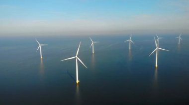 Okyanustaki yel değirmeni parkı, yeşil enerji üreten yel değirmeni türbinlerinin insansız hava görüntüsü Hollanda 'da denizde izole edilmiş yel değirmenleri. Yüksek kalite 4k görüntü