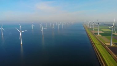Okyanustaki yel değirmeni parkı, yeşil enerji üreten yel değirmeni türbinlerinin insansız hava görüntüsü Hollanda 'da denizde izole edilmiş yel değirmenleri. Yüksek kalite 4k görüntü