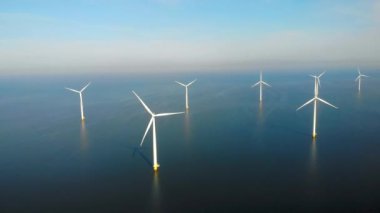 Okyanustaki yel değirmeni parkı, yeşil enerji üreten yel değirmeni türbinlerinin insansız hava görüntüsü Hollanda 'da denizde izole edilmiş yel değirmenleri. Yüksek kalite 4k görüntü