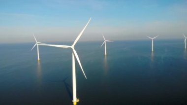 Okyanustaki yel değirmeni parkı, yeşil enerji üreten yel değirmeni türbinlerinin insansız hava görüntüsü Hollanda 'da denizde izole edilmiş yel değirmenleri. Yüksek kalite 4k görüntü