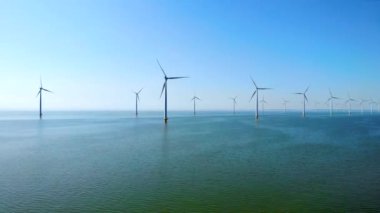 Okyanustaki yel değirmeni parkı, yeşil enerji üreten yel değirmeni türbinlerinin insansız hava görüntüsü Hollanda 'da denizde izole edilmiş yel değirmenleri. Yüksek kalite 4k görüntü