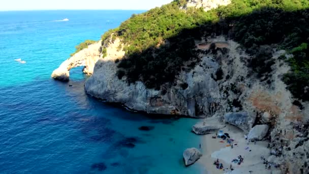 Golfo Orosei Sardina 从上方俯瞰 鸟瞰着布满海滩伞的海滩 人们在碧绿的水面上日光浴和游泳 Cala Gonone Sardinia Italy — 图库视频影像