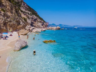 Golfo di Orosei Sardina, Sardinia İtalya sahilinde Asyalı kadınlar, İtalya 'da tatilde olan genç bir kız, açık mavi suyla okyanusta oynayan bir kadın.,