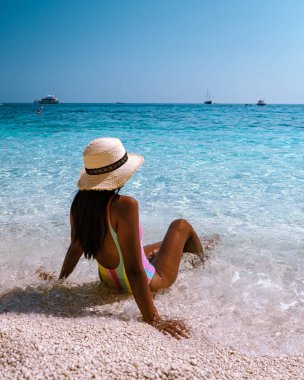Golfo di Orosei Sardina, Sardinia İtalya sahilinde Asyalı kadınlar, İtalya 'da tatilde olan genç bir kız, açık mavi suyla okyanusta oynayan bir kadın.,