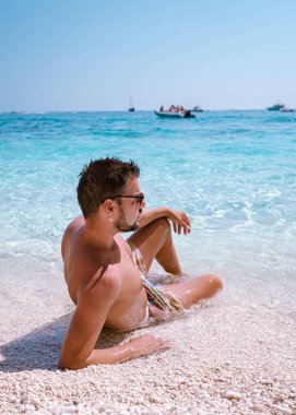 Golfo di Orosei Sardina, Sardinya sahilindeki erkekler, İtalya 'da tatilde olan genç adam, okyanusta kristal berrak mavi suyla oynayan adam, Yüksek kalite fotoğraf