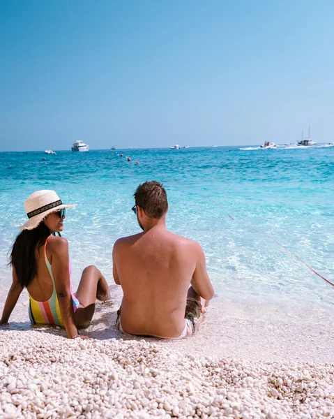 Golfo di Orosei Sardina, Men and women on the beach Sardinia Italy, young couple vacation Sardinia Italy, couple men and woman playing in the ocean with crystal clear blue water in Italy