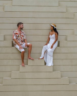 Modern bir Arap binasının merdivenlerinde dinlenen bir çift kadın ve erkek.